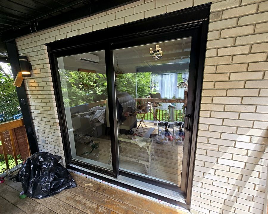 Nouvelle porte-patio noire et brique ajoutée à gauche.