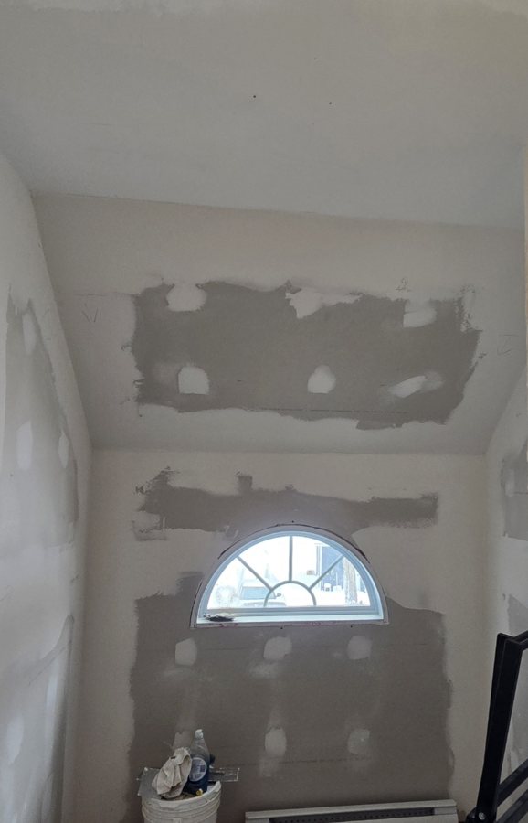 Murs refermés : gypse posé et joints tirés autour de la fenêtre.