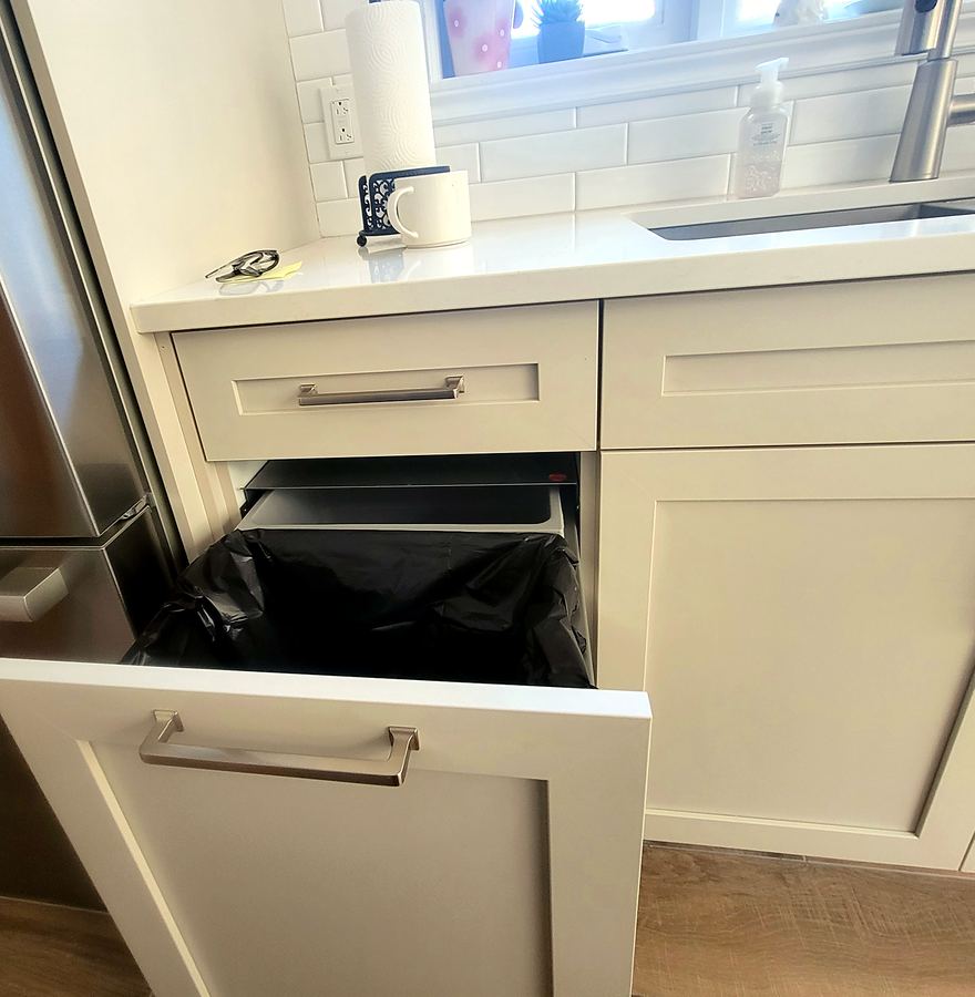 Tiroir à déchets coulissant intégré aux armoires.