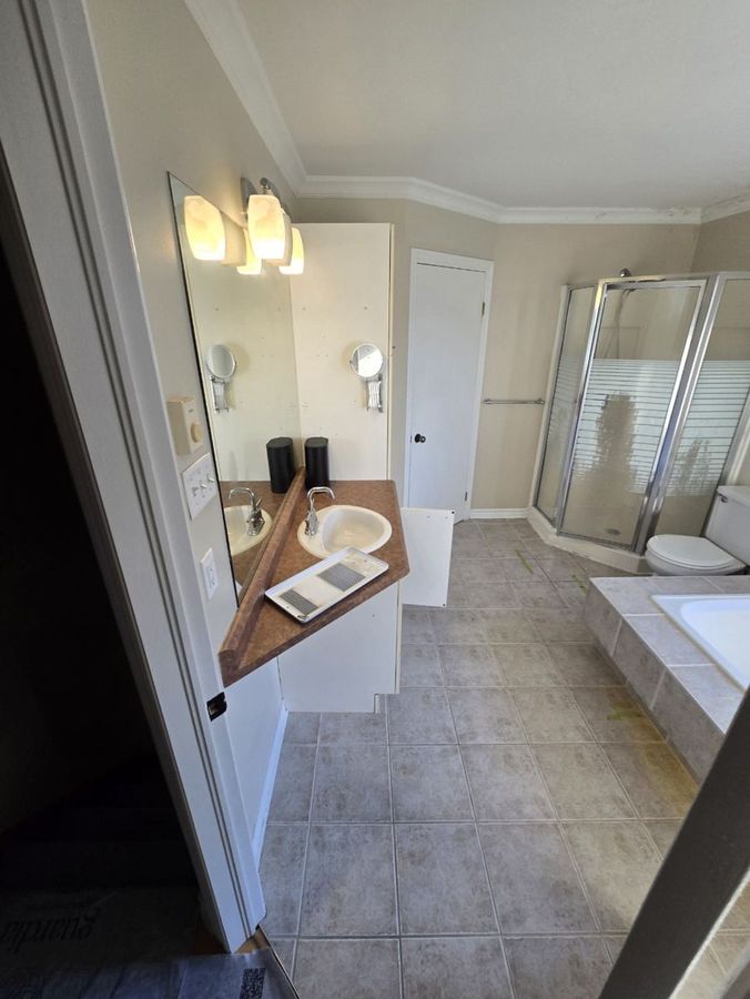 Salle de bain d'origine : vanité en stratifié, douche d'angle et bain encastré.