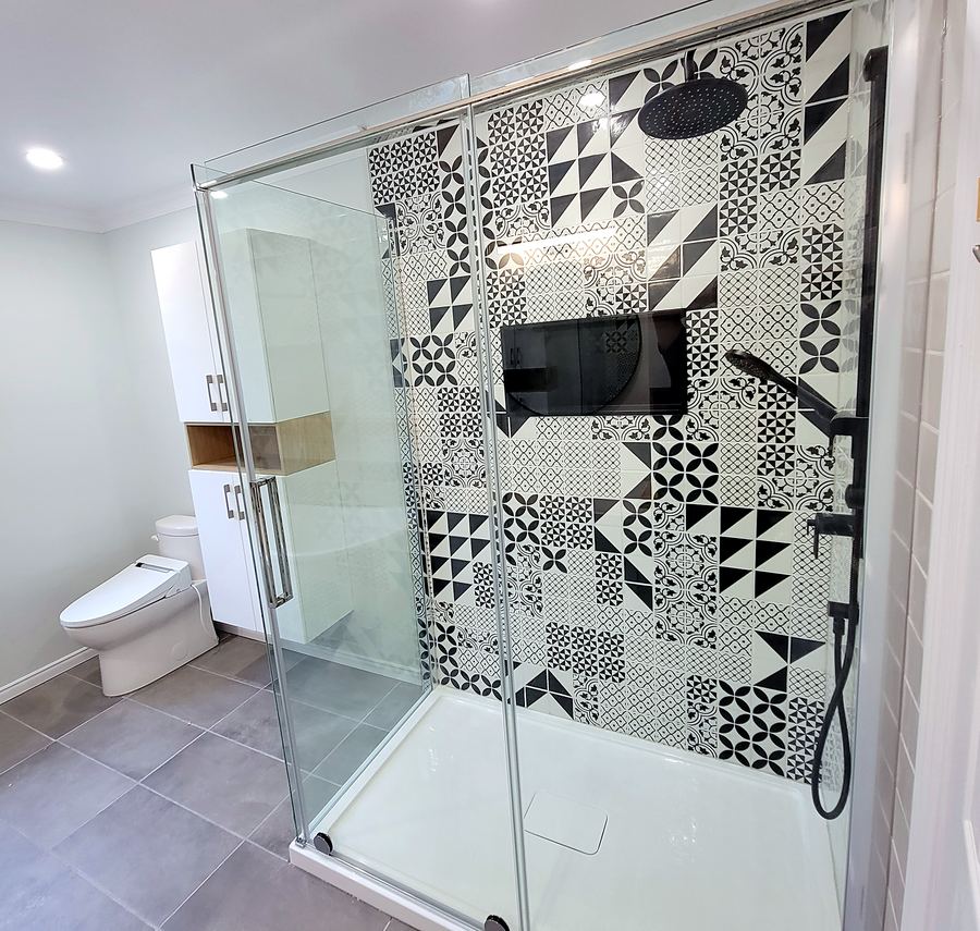 Douche vitrée avec céramique à motifs noir et blanc.