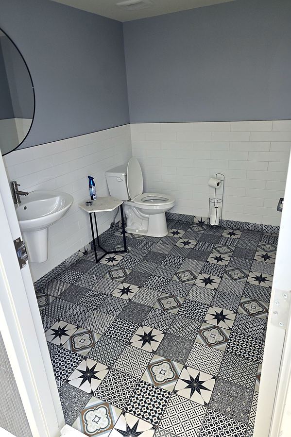 Plancher en céramique à motifs et lambris blanc.
