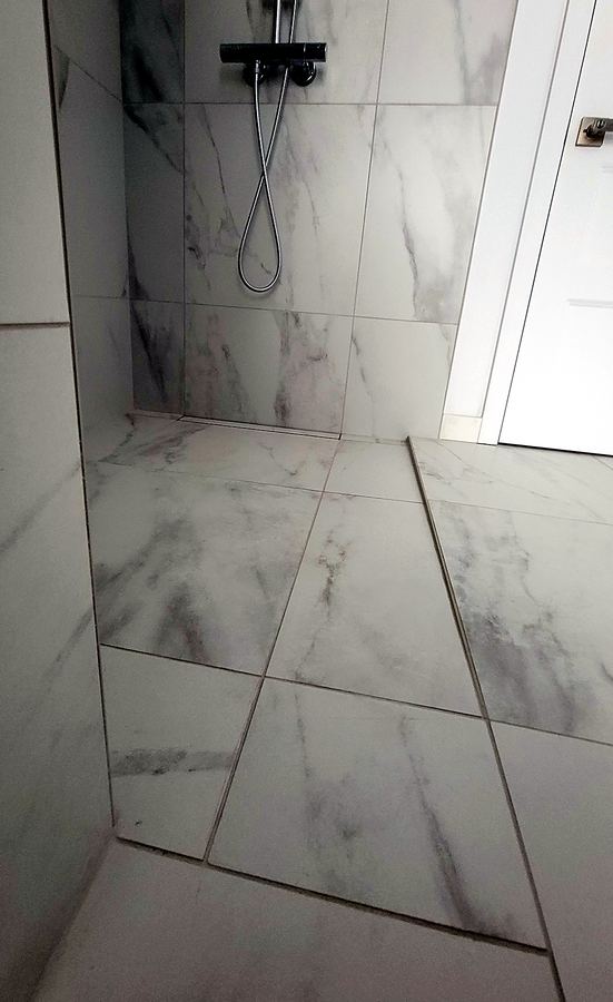 Drain linéaire intégré à la céramique de la douche.